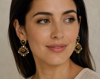 Pendientes barrocos con forma de piedra ovalada en tono dorado y detalles de diamantes de imitación.