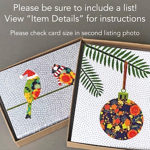 May include: Two Christmas cards with a gray background and white polka dots. One card features two birds with colorful patterned feathers perched on a branch. The other card features a green fern branch with a blue and orange patterned ornament hanging from it.