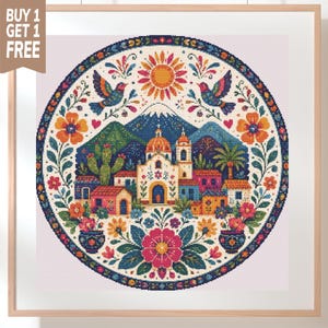Può includere: Un motivo a punto croce circolare con una chiesa centrale, case colorate, una montagna e un sole. Il design è incorniciato da fiori vivaci, fogliame e due uccelli. L'immagine include un banner marrone con il testo BUY 1 GET 1 FREE.
