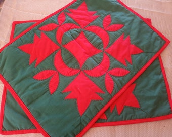 Set of two red and green holiday applique fabric placemats with hand accent stitching