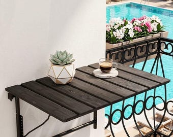 Peut inclure: Une table de balcon murale avec une surface à lattes en bois foncé et un cadre en métal noir. Un pot de succulente géométrique blanc et doré est posé sur la table à côté d'une tasse à café en verre sur un petit dessous de verre en marbre blanc.