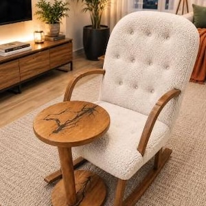 Pode incluir: Uma cadeira de balan&ccedil;o de sherpa branca tufada com apoios de bra&ccedil;os e base de madeira curva, combinada com uma mesa lateral redonda de madeira com um design de incrusta&ccedil;&atilde;o de resina escura ramificada no tampo e na base.