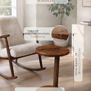 Pode incluir: Uma mesa lateral redonda feita de madeira de pinho maci&ccedil;a com acabamento castanho escuro. O di&acirc;metro do tampo &eacute; de 36 cm, a espessura &eacute; de 2 cm e a altura total &eacute; de 59 cm. A mesa possui uma base central e um tampo circular.