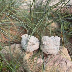 May include: A set of three ceramic mugs with a speckled, matte finish. The mugs are in shades of cream, light gray, and dark gray. Each mug has a simple, minimalist design and a rounded handle.