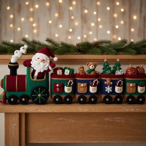 May include: A crocheted Christmas train advent calendar featuring a Santa Claus figure in the engine and four connected train cars. Each car has small pockets labeled with numbers, holding miniature crocheted items like bears, trees, and ornaments.