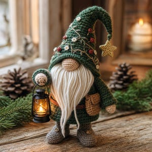Pode incluir: Uma figura de gnomo em crochê usando um chapéu pontudo verde-escuro decorado com pequenas flores brancas e bagas vermelhas, com uma longa barba de fio branco, nariz bege, botas cinzentas e uma pequena bolsa castanha, segurando uma lanterna preta.