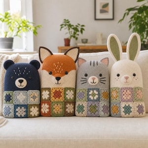 Peut inclure: Quatre coussins rectangulaires en crochet en forme d'animaux : un ours bleu foncé, un renard orange, un chat gris et un lapin crème. Chaque coussin présente une partie supérieure unie avec des détails faciaux brodés et une base en carrés granny.