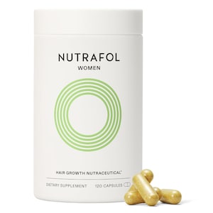 May include: A white cylindrical bottle of Nutrafol Women hair growth nutraceutical dietary supplement. The bottle has a green circular design and the text "Nutrafol Women". 120 capsules are included. Several capsules are scattered in front of the bottle.