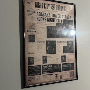 May include: A framed newspaper print titled Night City Chronicle featuring the headline Arasaka Tower Attack Rocks Night City. The layout includes various articles, images of characters, and advertisements for fictional companies like Kiroshi and Thorton.