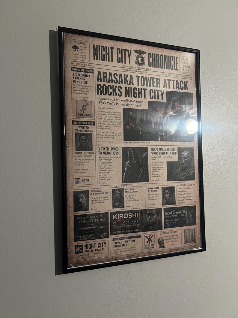 May include: A framed newspaper print titled Night City Chronicle featuring the headline Arasaka Tower Attack Rocks Night City. The layout includes various articles, images of characters, and advertisements for fictional companies like Kiroshi and Thorton.