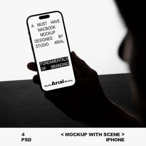 May include: A black smartphone displaying text: "A MUST HAVE MACBOOK MOCKUP DESIGNED BY STUDIO ARIAL FUNDAMENTALS OF BRANDING Studio Arial Mockup". The phone is held in a person's hand. The image also includes the text "4 PSD" and "< MOCKUP WITH SCENE > IPHONE".