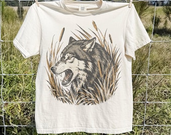 Klassisk t-shirt med grafisk design i form av ett ylande varg, t-shirt med rovdjur i vildmarken, t-shirt med rustik vildmarksäventyrsstil, t-shirt med Comfort Colors®-motiv och gåva