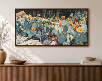 May include: A rectangular framed wall art print featuring a desert landscape with blue-green prickly pear cacti. The scene includes vibrant orange and yellow cactus flowers in full bloom, set against a dark background with rocky terrain.