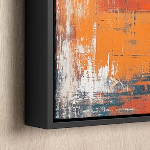 an orange and blue painting hanging on a wall