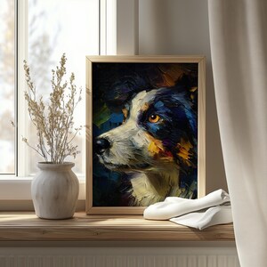 Op de afbeelding: Een ingelijst olieverfschilderij van een hondenprofiel, met zwart, wit en geel. Het kunstwerk staat op een houten vensterbank, naast een vaas met gedroogde planten en een gevouwen witte doek.