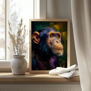 Op de afbeelding: Een ingelijste kunstdruk met een portret van een chimpansee. Het kunstwerk toont het gezicht van de primaat met gedetailleerde penseelstreken in tinten blauw, bruin en paars. De blik van de chimpansee is licht omhoog gericht, tegen een achtergrond van groen en geel.