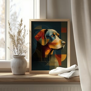 May include: A framed art print featuring a geometric dog portrait. The artwork showcases a dog's profile with a mix of colors, including orange, blue, and brown. The print is in a wooden frame, displayed on a wooden surface.