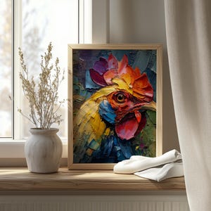 Op de afbeelding: Een ingelijst olieverfschilderij van een hanenkop. Het kunstwerk toont een levendig palet van geel, rood, blauw en paars, met zichtbare penseelstreken. Het schilderij staat tegen een neutrale achtergrond, wat een opvallend contrast creëert.