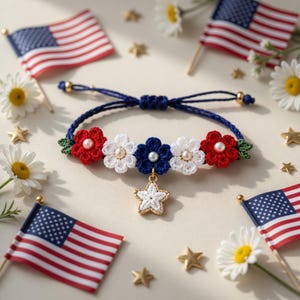 May include: A patriotic bracelet featuring red, white, and blue crocheted flowers with pearl centers. A gold star charm hangs below the flowers. The bracelet is surrounded by American flags, daisies, and gold stars.