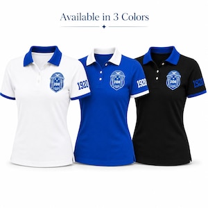 May include: Three short-sleeve polo shirts in white, blue, and black, each featuring a blue collar, a ZΦB crest on the chest, and the number 1920 on the sleeve. The text Available in 3 Colors is displayed above the shirts.
