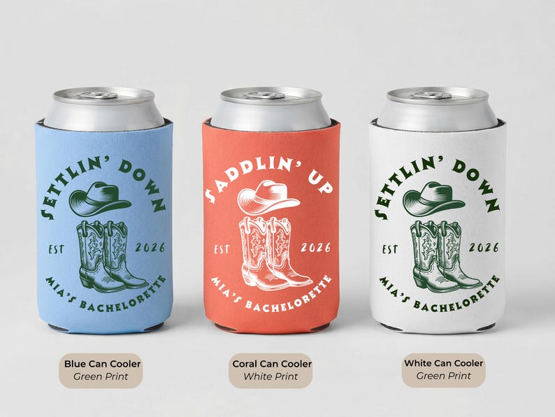 Puede incluir: Tres enfriadores de latas en azul, coral y blanco. El enfriador azul tiene un sombrero verde y un gr&aacute;fico de botas con el texto "Settlin' Down". El enfriador coral tiene un sombrero blanco y un gr&aacute;fico de botas con el texto "Saddlin' Up". El enfriador blanco tiene un sombrero verde y un gr&aacute;fico de botas con el texto "Settlin' Down".