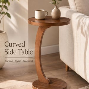 May include: A round wooden side table with a single curved support column and a circular base. The table surface holds a ceramic mug and a small vase with greenery. Text on the image reads: Curved Side Table, Compact, Stylish, Functional.