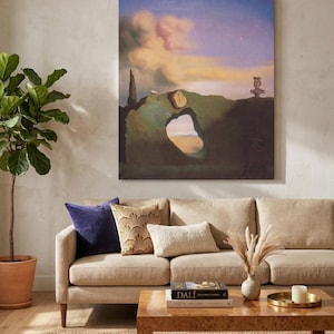 May include: A living room scene featuring a beige sofa with decorative pillows, a wooden coffee table, and a large framed artwork. The artwork depicts a surreal landscape with a blue sky and a mountain with a hole in it. A potted plant and a rug complete the scene.