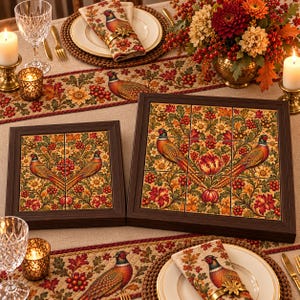 May include: Two square wooden-framed wall art pieces featuring a tiled mosaic design. The tiles display a vibrant autumn pattern with pheasants, oak leaves, berries, and flowers in shades of orange, red, gold, and green, set against a cream background.