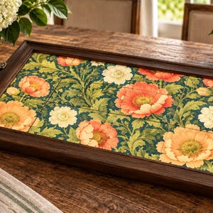 May include: A rectangular wooden serving tray with a dark brown finish and ornate metal handles on each side. The center features a tiled inlay displaying a vibrant botanical pattern of large orange and cream flowers set against a deep green background.