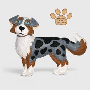 May include: A felt dog toy in a standing position, featuring a mix of colors including white, brown, gray, and black. The dog has a detailed design with a paw print and the text "DIGITAL PDF PATTERN".