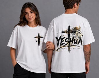 Può includere: Una t-shirt bianca con una piccola grafica a croce nera sul petto a sinistra. Il retro mostra una grande grafica di un leone che indossa una corona d'oro accanto a una croce nera, con il testo YESHUA e SALVATION IS IN HIS NAME.