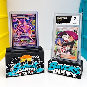 Pode incluir: Duas cartas colecionáveis em estojos protetores em suportes pretos. A carta da esquerda é um Mewtwo EX roxo, e a da direita é uma carta de treinador Jessie & James classificada como 7 Near Mint. Os suportes exibem o texto Southwest Cards TCG e Buyers Givvy.
