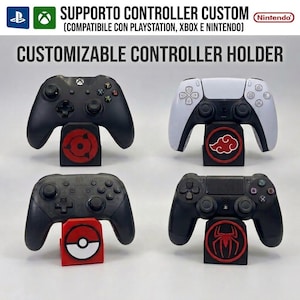 Könnte beinhalten: Vier schwarze und weiße Gaming-Controller auf individuellen Ständern. Die Ständer zeigen kreisförmige Embleme, darunter ein rot-schwarzes Auge, eine rote Wolke, eine rot-weiße Kugel und ein rotes Spinnensymbol. Text: CUSTOMIZABLE CONTROLLER HOLDER.