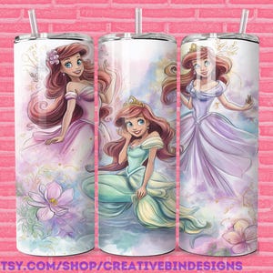 Puede incluir: Tres vasos de acero inoxidable con ilustraciones de una princesa pelirroja con diferentes vestidos. Los vasos tienen un fondo blanco con efecto acuarela y detalles florales. Cada vaso tiene una pajita y el texto "PNG".