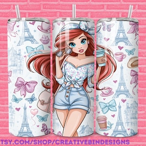 May include: A cylindrical tumbler with a straw featuring a cartoon illustration of a person with long red hair, a floral top, and denim shorts. The background pattern includes blue Eiffel Towers, pink bows, butterflies, coffee cups, and hearts.