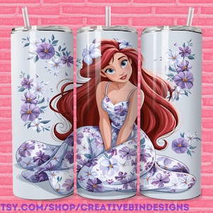 K&ouml;nnte beinhalten: Ein hellblauer Becher mit einer Cartoon-Meerjungfrau mit langen roten Haaren und einem Blumenkleid. Der Becher ist mit lila und wei&szlig;en Blumen verziert. Der Text "PNG" und "ETSY.COM/SHOP/CREATIVEBINDESIGNS" sind sichtbar.