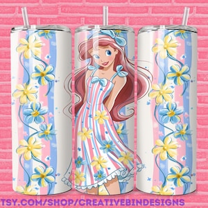 May include: A cylindrical tumbler featuring a cartoon character with long red hair and a blue bow, wearing a pink and white striped dress. The design includes vertical blue stripes and a pattern of yellow and blue flowers with a clear plastic straw.
