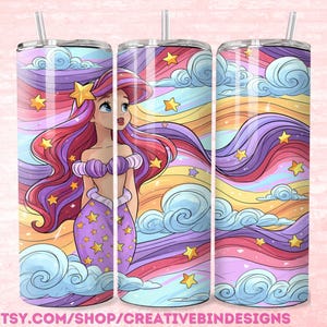 May include: A cylindrical tumbler featuring a cartoon mermaid with long red hair, a purple seashell top, and a purple tail. The design includes a colorful sky background with swirling blue clouds, yellow stars, and flowing rainbow-colored ribbons.