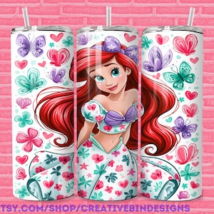 May include: A cylindrical tumbler featuring a cartoon character with long red hair, a purple shell top, and a white skirt with floral patterns. The design includes colorful butterflies and hearts in shades of pink, purple, and teal against a white background.