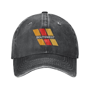May include: A dark gray baseball cap with a curved brim. The cap features a logo with the word "SOUTHWEST" in white, above a design of orange and red angled stripes.