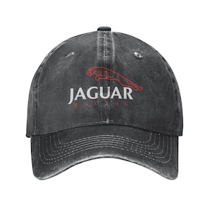 May include: A black baseball cap with the word "JAGUAR" in white block letters and a red jaguar logo. The word "RACING" is printed in red below the word "JAGUAR". The cap has a curved brim and a fabric strap closure.