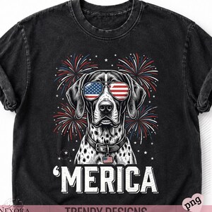 May include: A black short-sleeve t-shirt featuring a graphic of a spotted dog wearing sunglasses with American flag patterns. The design includes red, white, and blue fireworks, stars, and the text 'MERICA' in white capital letters at the bottom.