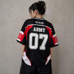 Op de afbeelding: Zwart mesh jersey met rode en witte accenten, met het woord "ARMY" en het nummer "07" in het wit. De jersey heeft ook Koreaanse tekst bovenaan en de nummers "6" en "1" op de mouwen.