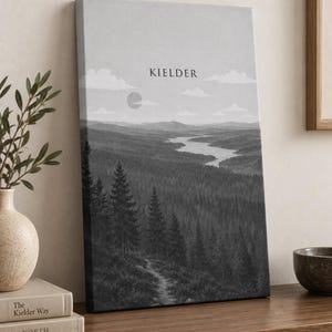 May include: A rectangular canvas wall art print in grayscale featuring a landscape of a dense pine forest, a winding river, and distant mountains under a sky with clouds and a sun. The word KIELDER is printed in black text at the top centre.