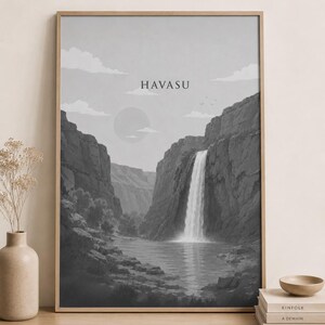 May include: A framed wall art print in grayscale featuring a landscape of a waterfall cascading into a pool between rocky canyon walls. The sky includes a circular sun and clouds, with the text HAVASU centred at the top of the print.
