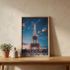 Può includere: Una stampa incorniciata della Torre Eiffel al tramonto, illuminata contro un cielo crepuscolare con scie di luce. L'opera d'arte è esposta su un tavolo di legno con una piccola pianta in vaso e un vaso.