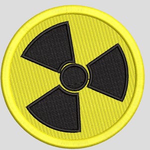 May include: A circular embroidered patch featuring a bright yellow background with a black radiation hazard symbol in the center. The design consists of a central black circle surrounded by three black fan-shaped blades, all bordered by a yellow edge.