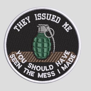 May include: A circular embroidered patch with a black background and a white border. It features a green hand grenade in the center and white text that reads: THEY ISSUED ME YOU SHOULD HAVE SEEN THE MESS I MADE.