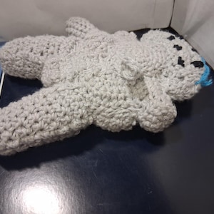 Może przedstawiać: Biały ceramiczny kubek z czarnym uchwytem i napisem "But First, Coffee" pogrubioną czcionką. Kubek jest ustawiony na rozmytym tle, sugerującym przytulne otoczenie.