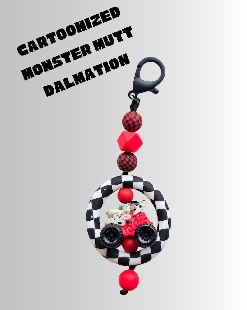 K&ouml;nnte beinhalten: Ein Schl&uuml;sselanh&auml;nger mit einem Cartoon-Dalmatiner, der einen roten Monstertruck in einem schwarz-wei&szlig; karierten Ring f&auml;hrt. Der Schl&uuml;sselanh&auml;nger hat rote und schwarze Perlen und den Text "Cartoonized Monster Mutt Dalmatian".